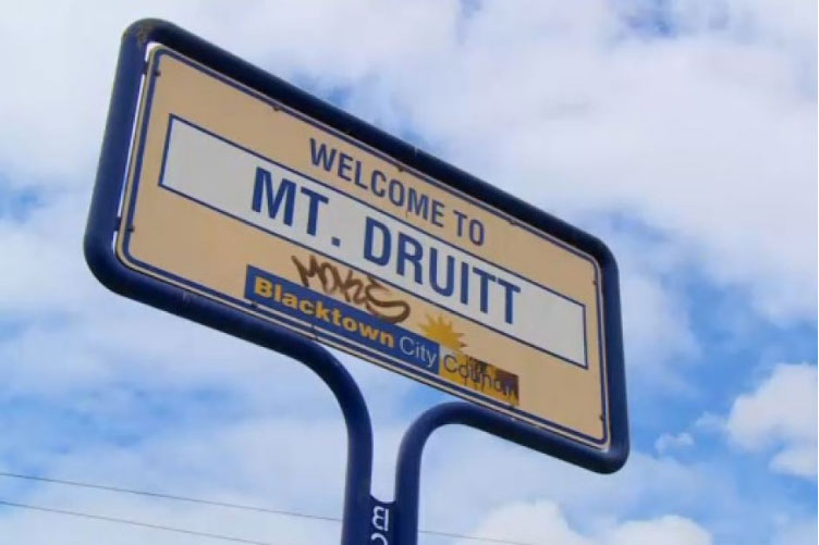 Picture of a graffitied sign saying welcome to Mount Druitt.